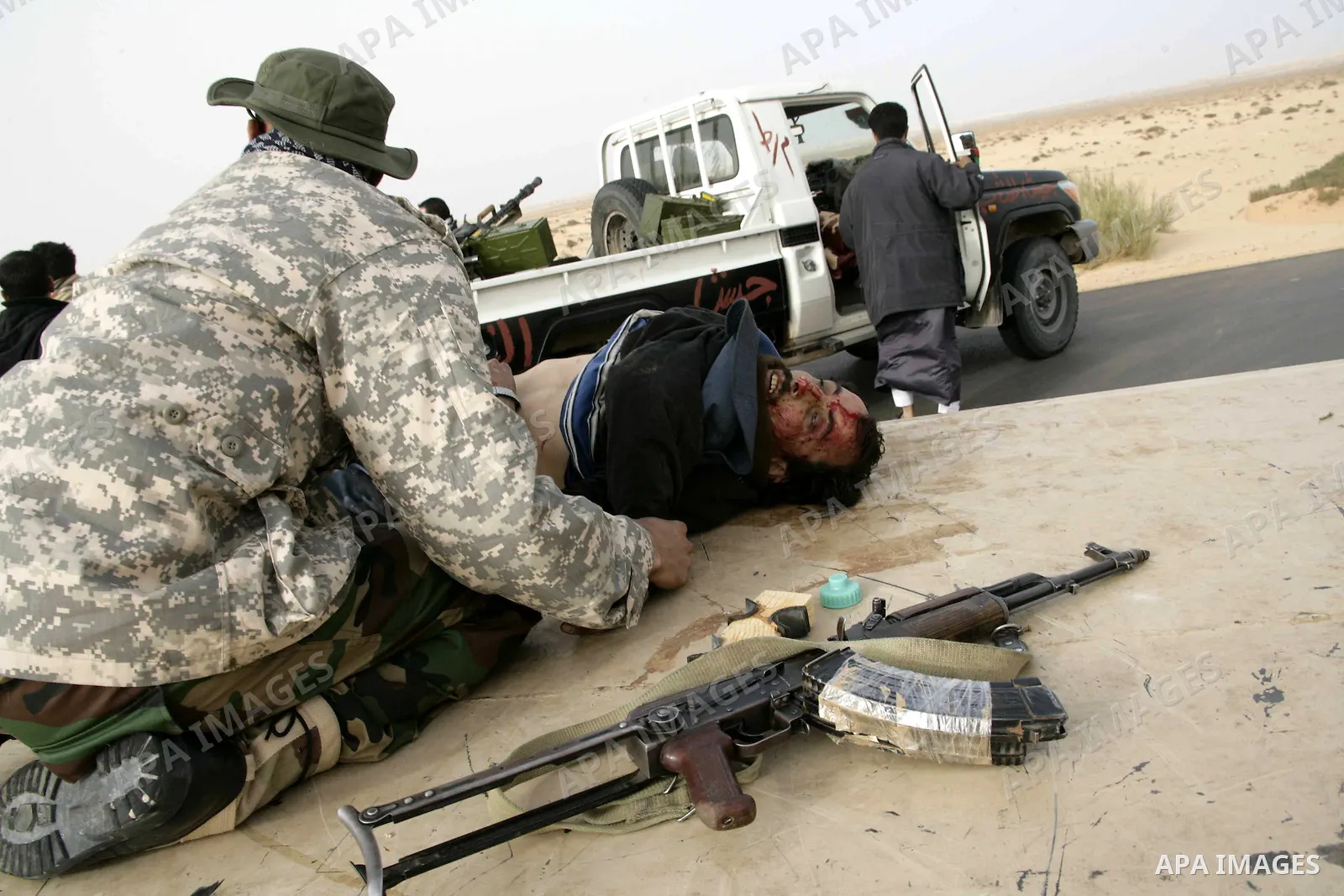 Rebel fighters take cover from shelling by soldiers loyal to Libyan leader Muammar Gaddafi during a battle near Ras Lanuf, March 4, 2011. Heavily armed rebels clashed with forces loyal to Gaddafi on Friday on the outskir...