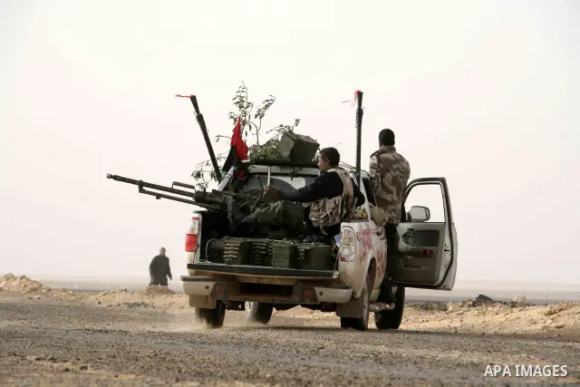 Rebel fighters return fire during shelling by soldiers loyal to Libyan leader Muammar Gaddafi in a battle near Ras Lanuf, March 4, 2011. Heavily armed rebels clashed with forces loyal to Gaddafi on Friday on the outskirt...