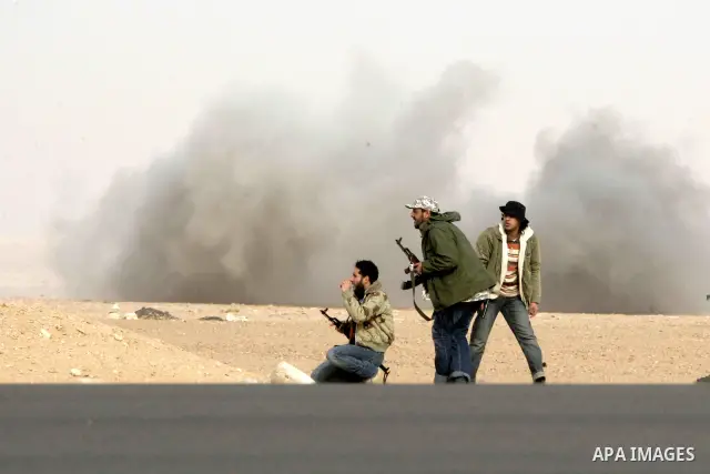 Rebel fighters return fire during shelling by soldiers loyal to Libyan leader Muammar Gaddafi in a battle near Ras Lanuf, March 4, 2011. Heavily armed rebels clashed with forces loyal to Gaddafi on Friday on the outskirt...