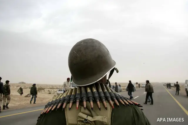 Rebel fighters return fire during shelling by soldiers loyal to Libyan leader Muammar Gaddafi in a battle near Ras Lanuf, March 4, 2011. Heavily armed rebels clashed with forces loyal to Gaddafi on Friday on the outskirt...