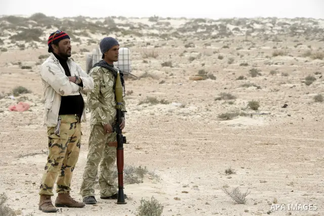 Rebel fighters return fire during shelling by soldiers loyal to Libyan leader Muammar Gaddafi in a battle near Ras Lanuf, March 4, 2011. Heavily armed rebels clashed with forces loyal to Gaddafi on Friday on the outskirt...