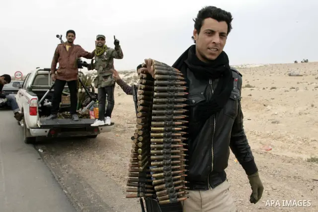 Rebel fighters return fire during shelling by soldiers loyal to Libyan leader Muammar Gaddafi in a battle near Ras Lanuf, March 4, 2011. Heavily armed rebels clashed with forces loyal to Gaddafi on Friday on the outskirt...
