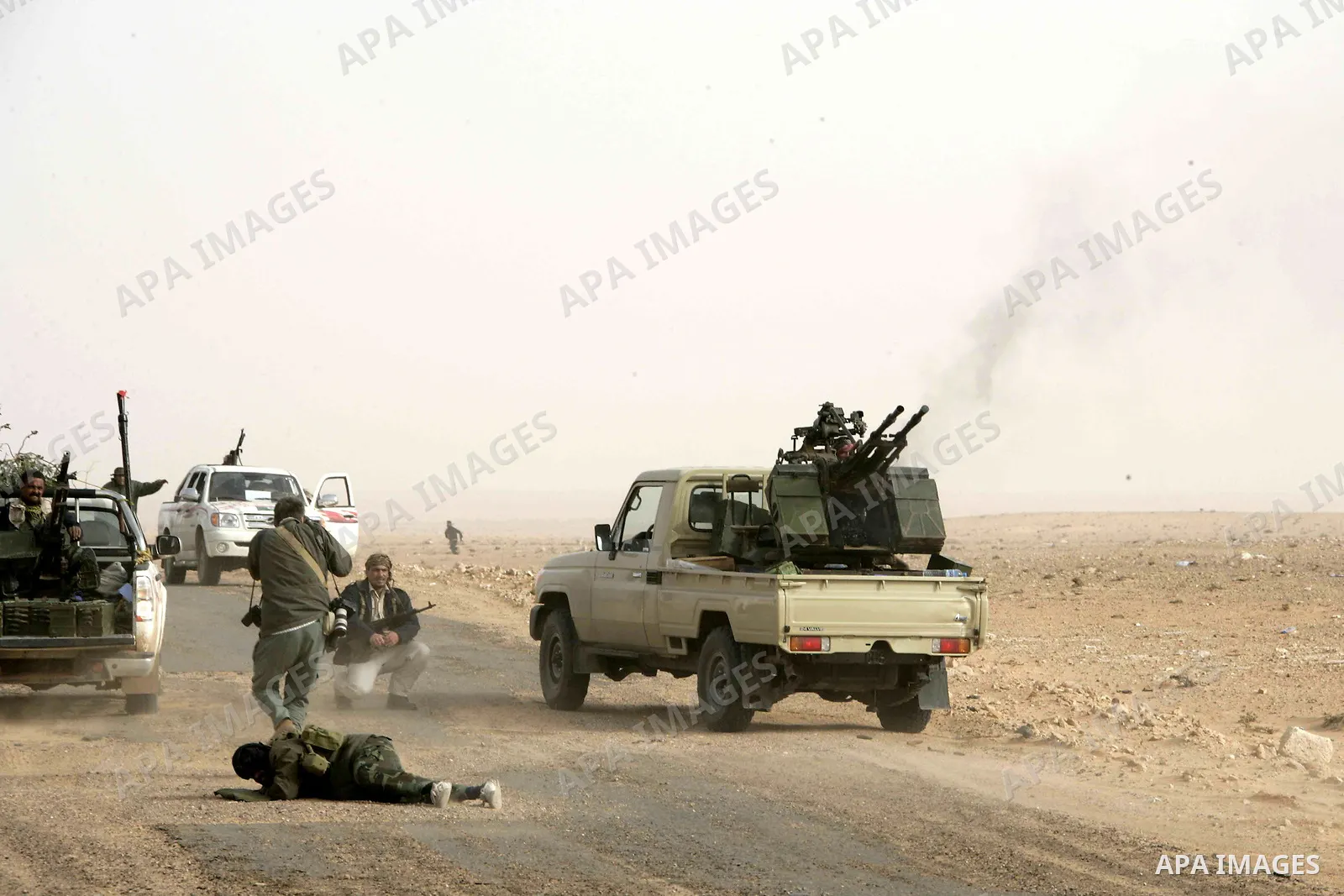Rebel fighters return fire during shelling by soldiers loyal to Libyan leader Muammar Gaddafi in a battle near Ras Lanuf, March 4, 2011. Heavily armed rebels clashed with forces loyal to Gaddafi on Friday on the outskirt...
