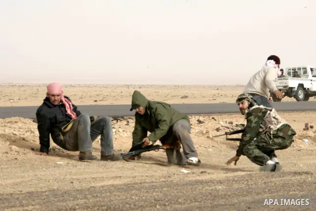 Rebel fighters return fire during shelling by soldiers loyal to Libyan leader Muammar Gaddafi in a battle near Ras Lanuf, March 4, 2011. Heavily armed rebels clashed with forces loyal to Gaddafi on Friday on the outskirt...