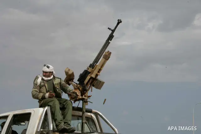 Rebel fighters return fire during shelling by soldiers loyal to Libyan leader Muammar Gaddafi in a battle near Ras Lanuf, March 4, 2011. Heavily armed rebels clashed with forces loyal to Gaddafi on Friday on the outskirt...