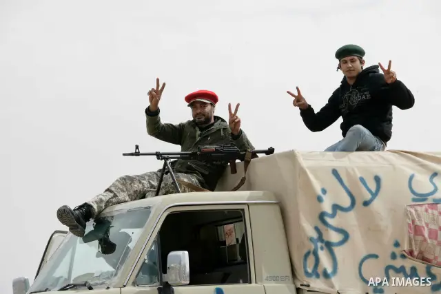 Rebel fighters return fire during shelling by soldiers loyal to Libyan leader Muammar Gaddafi in a battle near Ras Lanuf, March 4, 2011. Heavily armed rebels clashed with forces loyal to Gaddafi on Friday on the outskirt...