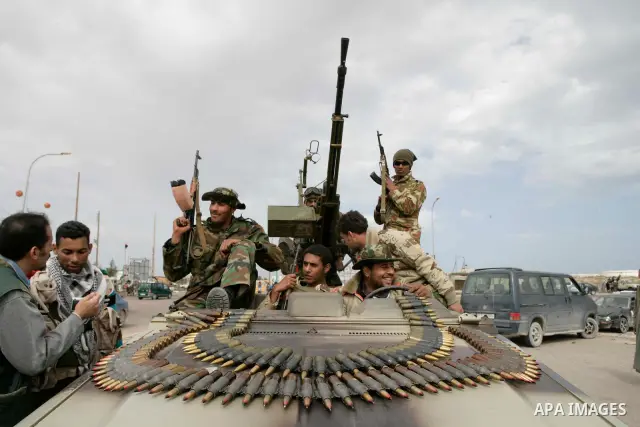 Rebel fighters return fire during shelling by soldiers loyal to Libyan leader Muammar Gaddafi in a battle near Ras Lanuf, March 4, 2011. Heavily armed rebels clashed with forces loyal to Gaddafi on Friday on the outskirt...