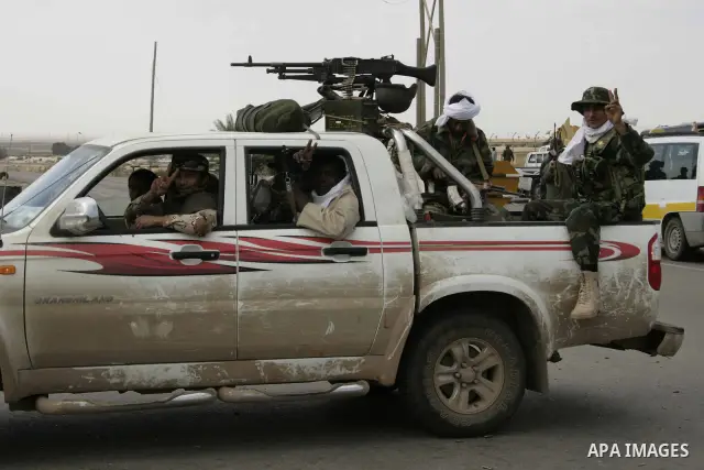 Rebel fighters return fire during shelling by soldiers loyal to Libyan leader Muammar Gaddafi in a battle near Ras Lanuf, March 4, 2011. Heavily armed rebels clashed with forces loyal to Gaddafi on Friday on the outskirt...