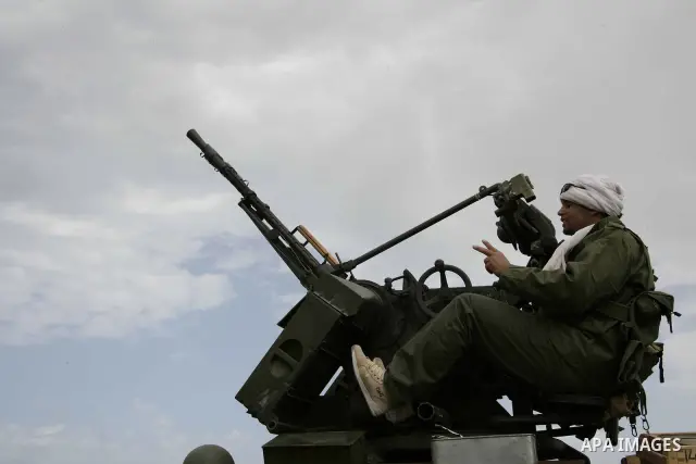 Rebel fighters return fire during shelling by soldiers loyal to Libyan leader Muammar Gaddafi in a battle near Ras Lanuf, March 4, 2011. Heavily armed rebels clashed with forces loyal to Gaddafi on Friday on the outskirt...