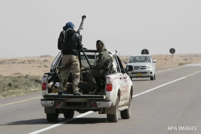 Rebel fighters return fire during shelling by soldiers loyal to Libyan leader Muammar Gaddafi in a battle near Ras Lanuf, March 4, 2011. Heavily armed rebels clashed with forces loyal to Gaddafi on Friday on the outskirt...