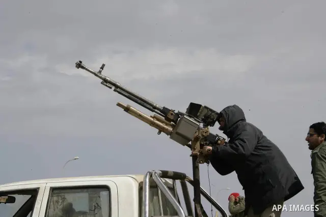 Rebel fighters return fire during shelling by soldiers loyal to Libyan leader Muammar Gaddafi in a battle near Ras Lanuf, March 4, 2011. Heavily armed rebels clashed with forces loyal to Gaddafi on Friday on the outskirt...