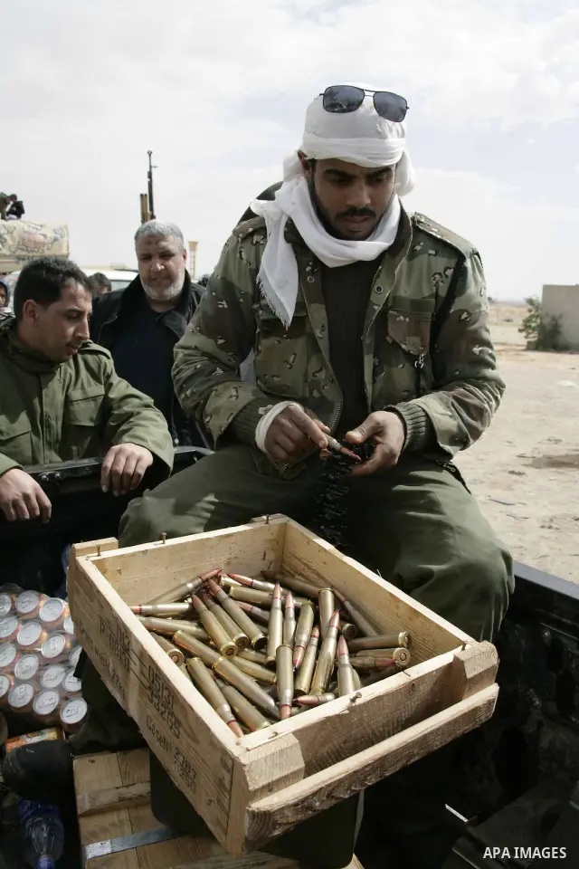 Rebel fighters return fire during shelling by soldiers loyal to Libyan leader Muammar Gaddafi in a battle near Ras Lanuf, March 4, 2011. Heavily armed rebels clashed with forces loyal to Gaddafi on Friday on the outskirt...