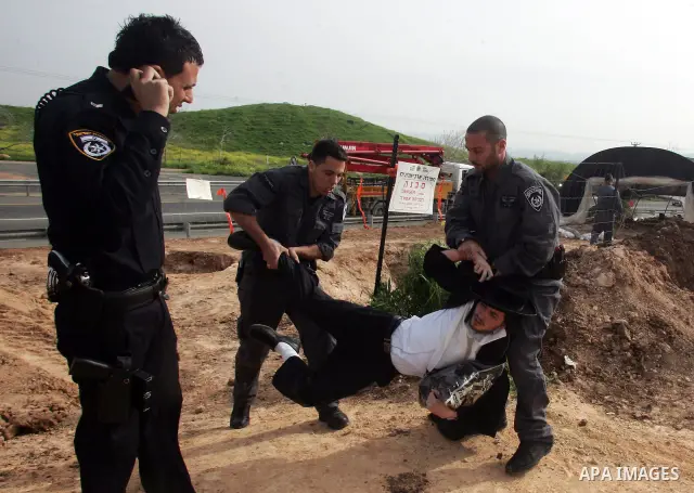 Israeli policeman arresting an ultra Orthodox during a protest against dig tombs in Haifa, on march 6, 2011. Photo by Mahfouz Abu Turk