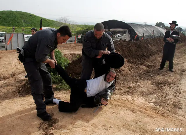 Israeli policeman arresting an ultra Orthodox during a protest against dig tombs in Haifa, on march 6, 2011. Photo by Mahfouz Abu Turk