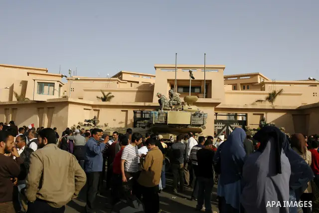 Egyptian protesters chant slogans during a demonstration in front of an Egyptian state security building in the outskirts of Cairo on Mach 5, 2011 while state security employees briefly fired gunshots as hundreds of prot...