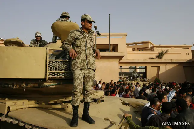 Egyptian protesters chant slogans during a demonstration in front of an Egyptian state security building in the outskirts of Cairo on Mach 5, 2011 while state security employees briefly fired gunshots as hundreds of prot...