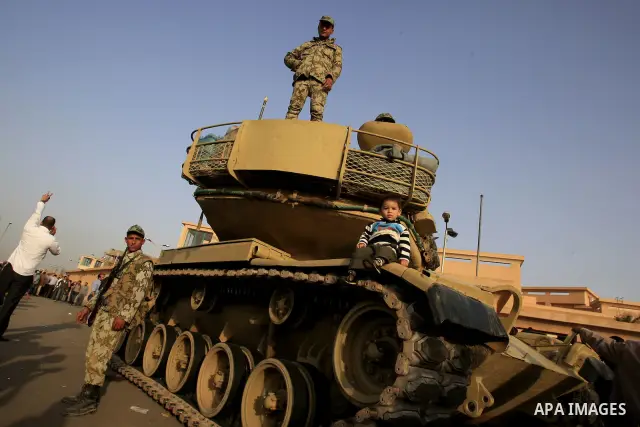 Egyptian protesters chant slogans during a demonstration in front of an Egyptian state security building in the outskirts of Cairo on Mach 5, 2011 while state security employees briefly fired gunshots as hundreds of prot...