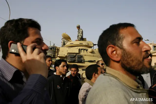 Egyptian protesters chant slogans during a demonstration in front of an Egyptian state security building in the outskirts of Cairo on Mach 5, 2011 while state security employees briefly fired gunshots as hundreds of prot...