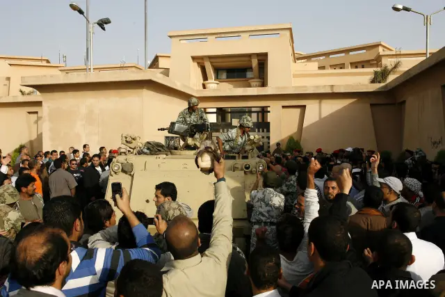 Egyptian protesters chant slogans during a demonstration in front of an Egyptian state security building in the outskirts of Cairo on Mach 5, 2011 while state security employees briefly fired gunshots as hundreds of prot...