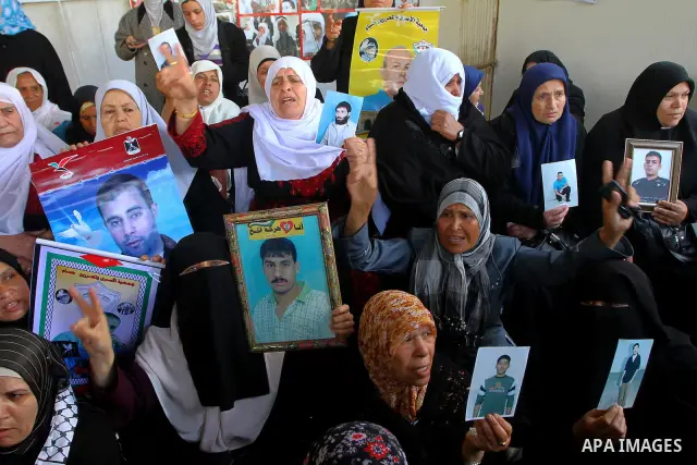 Palestinian women hold pictures of jailed relatives during a protest calling for the release of Palestinian prisoners from Israeli jails at the Red Cross office in Gaza City on March. 7,2011. Photo by Ashraf Amra