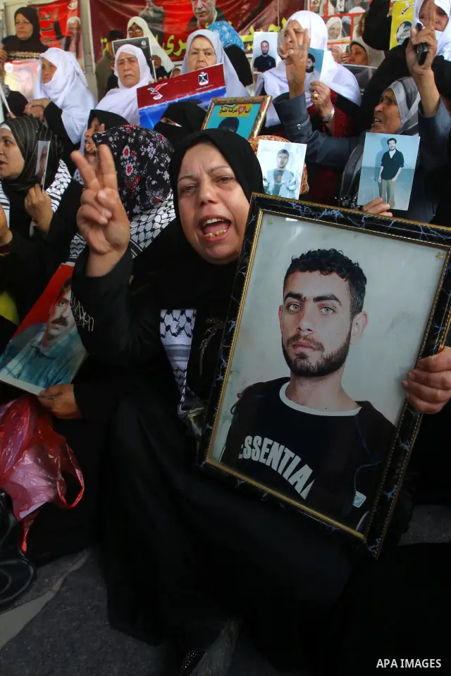 Palestinian women hold pictures of jailed relatives during a protest calling for the release of Palestinian prisoners from Israeli jails at the Red Cross office in Gaza City on March. 7,2011. Photo by Ashraf Amra