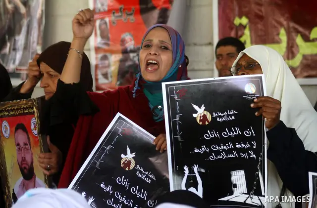 Palestinian women hold pictures of jailed relatives during a protest calling for the release of Palestinian prisoners from Israeli jails at the Red Cross office in Gaza City on March. 7,2011. Photo by Ashraf Amra