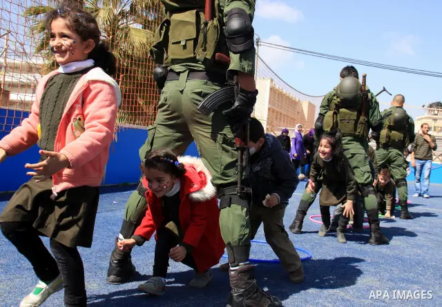 Palestinian security officers play with school children during a celebration in the West Bank city of Nablus, Monday, March 7, 2011. Photo by Wagdi Eshtayah