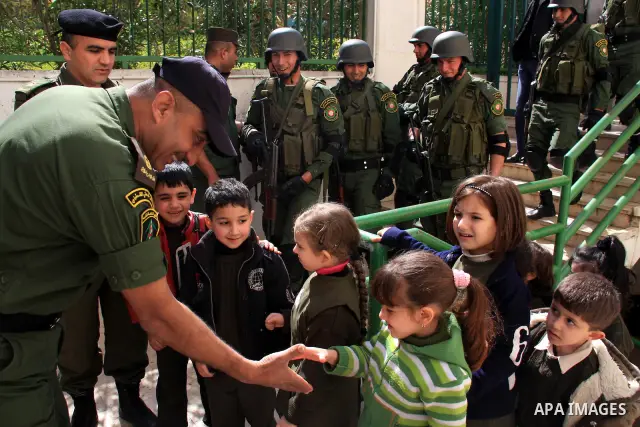 Palestinian security officers play with school children during a celebration in the West Bank city of Nablus, Monday, March 7, 2011. Photo by Wagdi Eshtayah
