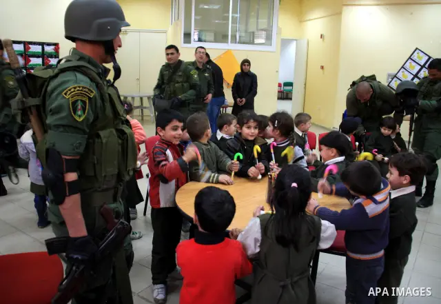 Palestinian security officers play with school children during a celebration in the West Bank city of Nablus, Monday, March 7, 2011. Photo by Wagdi Eshtayah