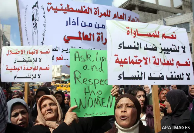 Palestinian women hold placards to mark the International Women Day in the West Bank city of Hebron, on March 08 2011.Photo by Najeh Hashlamoun