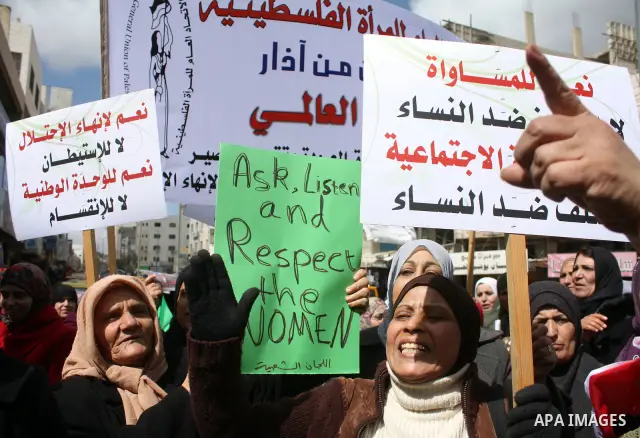 Palestinian women hold placards to mark the International Women Day in the West Bank city of Hebron, on March 08 2011.Photo by Najeh Hashlamoun