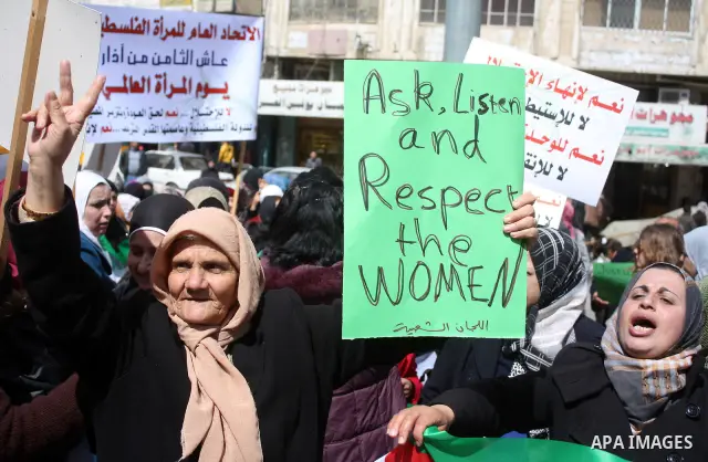 Palestinian women hold placards to mark the International Women Day in the West Bank city of Hebron, on March 08 2011.Photo by Najeh Hashlamoun