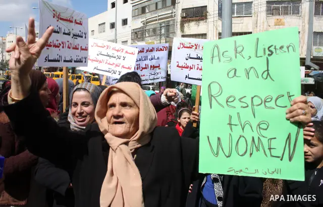 Palestinian women hold placards to mark the International Women Day in the West Bank city of Hebron, on March 08 2011.Photo by Najeh Hashlamoun