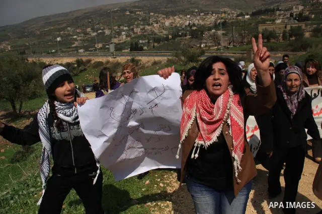 Palestinian women shout slogans during women's demonstration in the West Bank village of Burin, near Nablus, Tuesday ,March 8, 2011. The protest was organized by Palestinian women to mark the International Women's Day an...