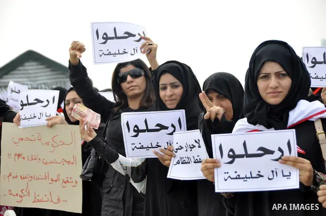 Bahraini anti-government women protesters wave flags and hold signs Tuesday, March 8, 2011, in Manama, Bahrain, to mark the International Woman Day. Photo by Ammar A.rasool