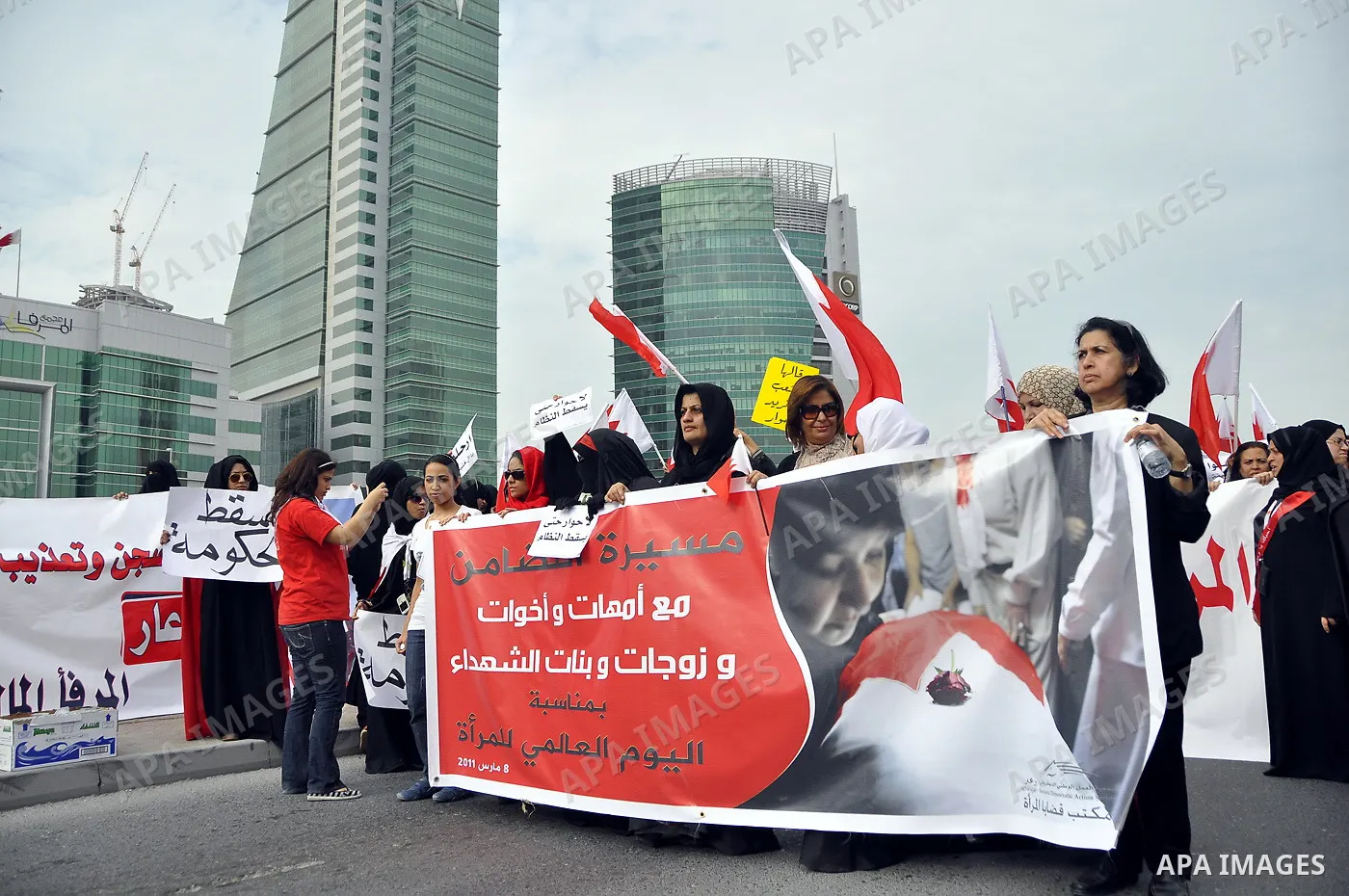 Bahraini anti-government women protesters wave flags and hold signs Tuesday, March 8, 2011, in Manama, Bahrain, to mark the International Woman Day. Photo by Ammar A.rasool
