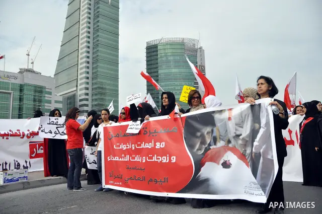 Bahraini anti-government women protesters wave flags and hold signs Tuesday, March 8, 2011, in Manama, Bahrain, to mark the International Woman Day. Photo by Ammar A.rasool