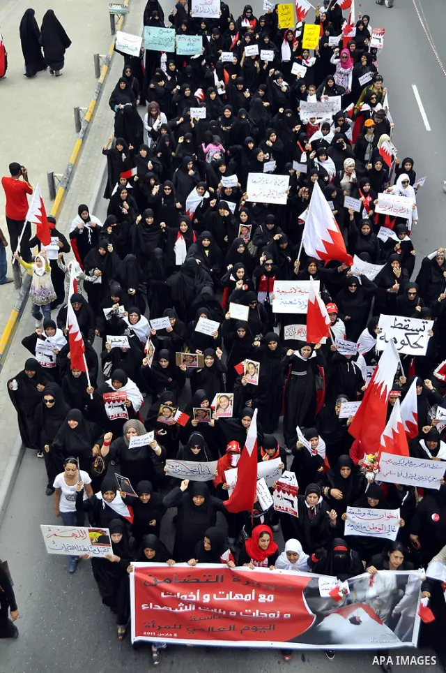 Bahraini anti-government women protesters wave flags and hold signs Tuesday, March 8, 2011, in Manama, Bahrain, to mark the International Woman Day. Photo by Ammar A.rasool
