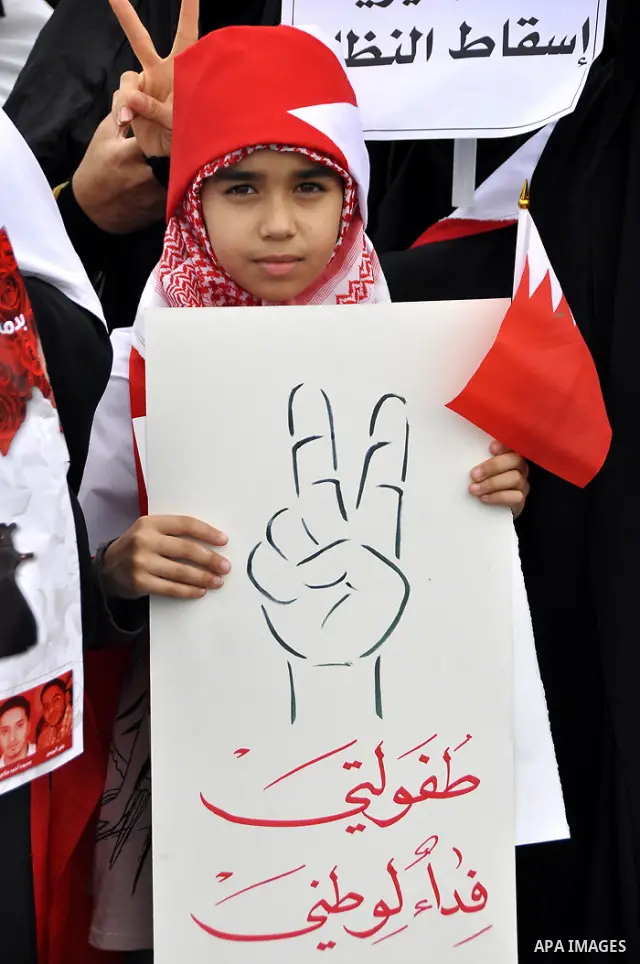 Bahraini anti-government women protesters wave flags and hold signs Tuesday, March 8, 2011, in Manama, Bahrain, to mark the International Woman Day. Photo by Ammar A.rasool