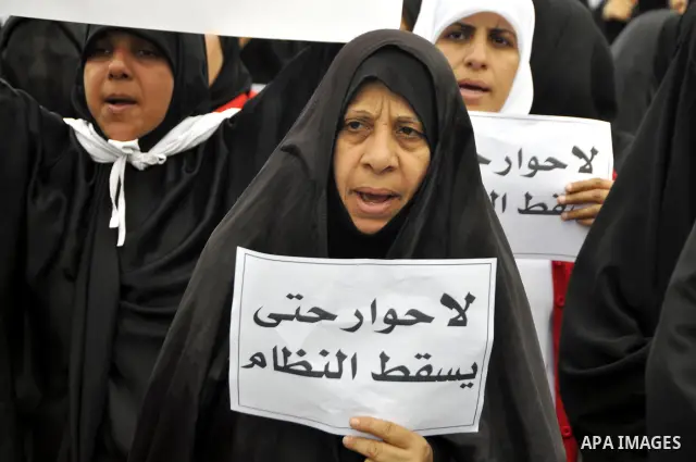 Bahraini anti-government women protesters wave flags and hold signs Tuesday, March 8, 2011, in Manama, Bahrain, to mark the International Woman Day. Photo by Ammar A.rasool