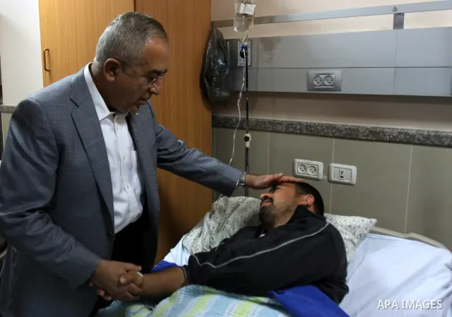 Palestinian Prime Minister Salam Fayyad visits the wounded Palestinians who injured during attack by Israeli settlers, at Rafidia hospital in the West Bank city of Nablus ,Tuesday, March 8, 2011. Jewish settlers opened f...
