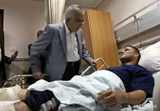 Palestinian Prime Minister Salam Fayyad pays a visit to Rafidya hospital in the West Bank city of Nablus on 08 March 2011, to meet some of the ten Palestinians wounded during the previous day clashes with Jewish settlers...