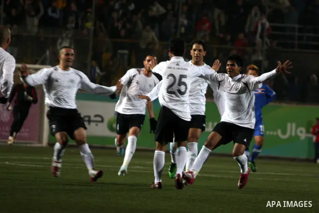 Palestinian (white) and Thailand national football players fight for the ball during their qualifier match for the Asian group of the 2012 London Olympics on March 9, 2011 at the Faisal Husseini stadium in the West Bank...