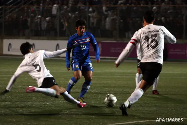 Palestinian (white) and Thailand national football players fight for the ball during their qualifier match for the Asian group of the 2012 London Olympics on March 9, 2011 at the Faisal Husseini stadium in the West Bank...