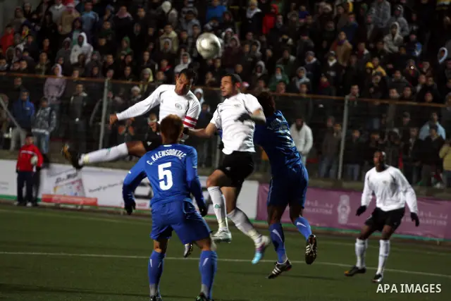 Palestinian (white) and Thailand national football players fight for the ball during their qualifier match for the Asian group of the 2012 London Olympics on March 9, 2011 at the Faisal Husseini stadium in the West Bank...