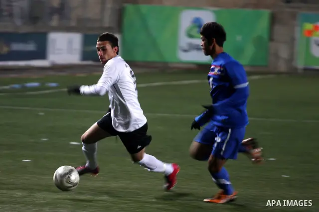 Palestinian (white) and Thailand national football players fight for the ball during their qualifier match for the Asian group of the 2012 London Olympics on March 9, 2011 at the Faisal Husseini stadium in the West Bank...