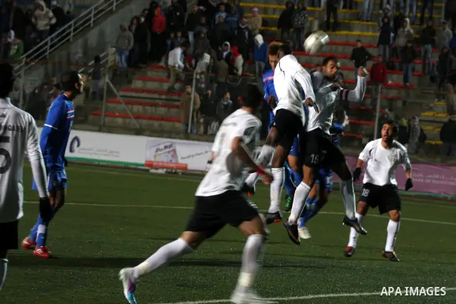 Palestinian (white) and Thailand national football players fight for the ball during their qualifier match for the Asian group of the 2012 London Olympics on March 9, 2011 at the Faisal Husseini stadium in the West Bank...