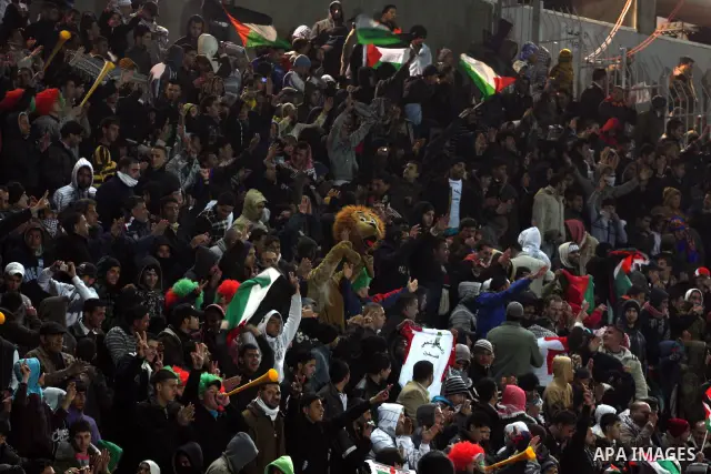 Palestinian fans watch their national football team play against Thailand during their qualifier for the Asian group of the 2012 London Olympics on March 9, 2011 at the Faisal Husseini stadium in the West Bank town of al...