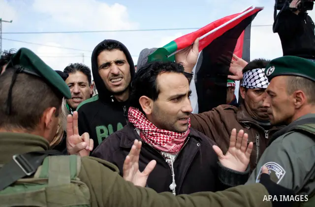 Protesters argue with Israeli soldiers during a demonstration against Israel's controversial separation barrier in the West Bank village of Maasarah, near the biblical town of Bethlehem on March 11, 2011.Israel says the...