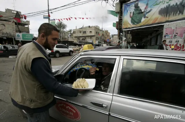 Palestinians distribute desserts celebrating the attack at the Jewish settlement of Itmar near Nablus in Rafah on March 12, 2011. A Palestinian infiltrated Itamar early Saturday and killed five people, the Israeli milita...